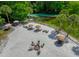 Aerial view showcasing a sandy beach area with lounge chairs, fire pit and picnic tables, perfect for outdoor relaxation and entertainment at 6583 River Run Blvd # 21005, Weeki Wachee, FL 34607