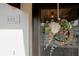 Close-up of a welcoming front door adorned with a floral wreath and stylish house number, creating a charming and inviting entrance at 6583 River Run Blvd # 21005, Weeki Wachee, FL 34607