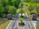 View of the neighborhood entrance, with stone pillars, black gates, and lush landscaping at 6583 River Run Blvd # 21005, Weeki Wachee, FL 34607