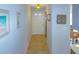 Bright hallway featuring tile flooring, neutral paint, decorative wall art, and views of the kitchen at 6583 River Run Blvd # 21005, Weeki Wachee, FL 34607