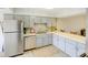 Spacious kitchen featuring stainless steel appliances, bright countertops, light gray cabinetry, and tile flooring at 6583 River Run Blvd # 21005, Weeki Wachee, FL 34607
