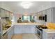 Open-concept kitchen with stainless steel appliances, light cabinetry, and an adjacent living area with ample natural light at 6583 River Run Blvd # 21005, Weeki Wachee, FL 34607
