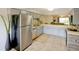 Modern kitchen featuring stainless steel appliances, light gray cabinets, tile flooring, and an adjacent living area at 6583 River Run Blvd # 21005, Weeki Wachee, FL 34607