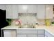 Bright kitchen features a stainless steel sink, modern appliances, mosaic backsplash, and light gray cabinets at 6583 River Run Blvd # 21005, Weeki Wachee, FL 34607