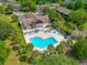 Aerial view of the community pool, featuring lounge chairs, a spa, and mature trees at 6583 River Run Blvd # 21005, Weeki Wachee, FL 34607