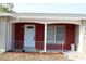 Welcoming front porch with brick accents, white railing, and landscaped flower beds at 7014 Jasmine Blvd, Port Richey, FL 34668