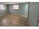 Light-filled bedroom with wood floors, two windows, and a sliding barn door at 7331 Sandalwood Dr, Port Richey, FL 34668