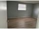 Serene bedroom with neutral walls, wood floors, and a window offering natural light at 7331 Sandalwood Dr, Port Richey, FL 34668