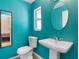 Bright blue bathroom features a pedestal sink, toilet, and framed mirror at 7464 Acorn Cir, Spring Hill, FL 34606