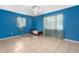 Bright bedroom with blue walls, tile floor, and natural light from a window at 7464 Acorn Cir, Spring Hill, FL 34606