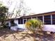 Backyard exterior with a large window and door, and grass lawn and palm tree at 7632 Lake Forest Cir, Port Richey, FL 34668