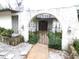A gated entryway with arched stonework, black wrought iron, and a walkway to the front door at 7632 Lake Forest Cir, Port Richey, FL 34668