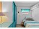The bedroom features a single bed, window with valance and blue storage at 800 Chesapeake Dr # 42, Tarpon Springs, FL 34689