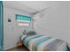 The bedroom features a single bed, window with valance and blue storage at 800 Chesapeake Dr # 42, Tarpon Springs, FL 34689