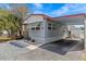 Well-maintained gray home featuring a carport and a nicely landscaped front yard at 800 Chesapeake Dr # 42, Tarpon Springs, FL 34689