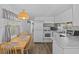 Bright kitchen features white cabinets, modern appliances, an adjacent dining area, and hardwood floors at 800 Chesapeake Dr # 42, Tarpon Springs, FL 34689