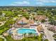 Community aerial view featuring the pool, spa, clubhouse, and surrounding lush landscaping at 8001 Summerbreeze Ter, Spring Hill, FL 34606