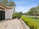 Stone back patio surrounded by lush landscaping and hedges, perfect for outdoor relaxation at 8001 Summerbreeze Ter, Spring Hill, FL 34606