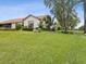 Well-maintained backyard featuring lush lawn, mature trees, and manicured landscaping beds at 8001 Summerbreeze Ter, Spring Hill, FL 34606