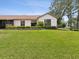 Expansive backyard featuring lush lawn, manicured landscaping, and a charming one-story home at 8001 Summerbreeze Ter, Spring Hill, FL 34606