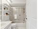 Bright bathroom featuring tiled shower with sliding glass doors, open shelves, and a white vanity sink at 8001 Summerbreeze Ter, Spring Hill, FL 34606