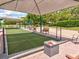 Shaded bocce ball court featuring well-maintained grounds, seating, and landscaping for a relaxing outdoor experience at 8001 Summerbreeze Ter, Spring Hill, FL 34606