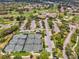 Aerial view of community amenities with tennis courts, parking and a community center near the golf course at 8001 Summerbreeze Ter, Spring Hill, FL 34606
