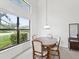 Cozy dining area with a wooden table set, ample natural light from large windows, and a serene view at 8001 Summerbreeze Ter, Spring Hill, FL 34606