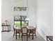 Inviting dining area with a wooden table set, natural light from large windows, and serene views of nature at 8001 Summerbreeze Ter, Spring Hill, FL 34606