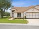 Well-manicured home featuring a two-car garage, neutral paint, and beautiful landscaping at 8001 Summerbreeze Ter, Spring Hill, FL 34606