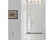 Bright, airy foyer with tile flooring, a white front door with glass pane, and a decorative painting at 8001 Summerbreeze Ter, Spring Hill, FL 34606