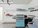 Bright garage featuring built in storage shelves and blue gas grill at 8001 Summerbreeze Ter, Spring Hill, FL 34606