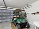 Well lit garage featuring a golf cart and a door leading to the home's interior at 8001 Summerbreeze Ter, Spring Hill, FL 34606