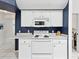 White stove and microwave in the kitchen, complemented by white cabinets and blue accent wall at 8001 Summerbreeze Ter, Spring Hill, FL 34606