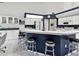 Bright kitchen with a breakfast bar, modern appliances, and white cabinets contrasting with navy blue at 8001 Summerbreeze Ter, Spring Hill, FL 34606