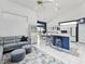 Open concept living space with a gray sectional, dining area, kitchen, and breakfast bar at 8001 Summerbreeze Ter, Spring Hill, FL 34606