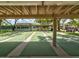 Community shuffleboard courts featuring multiple well-maintained playing surfaces and shaded seating with golf carts nearby at 8001 Summerbreeze Ter, Spring Hill, FL 34606
