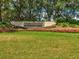 Entrance sign to Timber Pines community with manicured lawn and colorful flowerbeds at 8001 Summerbreeze Ter, Spring Hill, FL 34606
