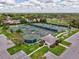Aerial view of the community tennis courts, featuring multiple well-maintained courts with shaded seating and a nearby parking area at 8001 Summerbreeze Ter, Spring Hill, FL 34606