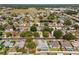 Wide aerial view of a residential neighborhood with a pond and houses with well-maintained yards at 8749 Aruba Ln, Port Richey, FL 34668