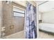 The tiled bathroom has a tub with shower and window at 8749 Aruba Ln, Port Richey, FL 34668
