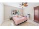 Bright bedroom with ceiling fan, tile floors, and a playful, themed decor at 8749 Aruba Ln, Port Richey, FL 34668