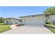 The home's driveway leads to an attached two-car garage, framed by a well-kept lawn at 8749 Aruba Ln, Port Richey, FL 34668