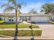 Charming single-story home with well-manicured lawn, palm tree, and inviting walkway at 8749 Aruba Ln, Port Richey, FL 34668