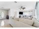 Bright living room featuring a large sectional sofa, tile flooring, and decorative window treatments at 8749 Aruba Ln, Port Richey, FL 34668