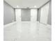Spacious basement with sleek marble floors, and white doors that enhance the room's brightness at 9200 Lunar Ln, Port Richey, FL 34668