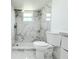 Bathroom featuring a shower with elegant marble tiling, modern fixtures and a white toilet at 9200 Lunar Ln, Port Richey, FL 34668