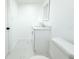 Clean, all-white bathroom features a toilet, vanity and mirrored wall at 9200 Lunar Ln, Port Richey, FL 34668
