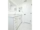 Bright bathroom features a sleek vanity with modern fixtures, marble floors and a mirrored wall at 9200 Lunar Ln, Port Richey, FL 34668