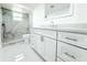 Bright bathroom featuring a shower with elegant marble tiling, a modern sink, and white cabinets at 9200 Lunar Ln, Port Richey, FL 34668
